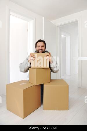 Man with boxes moving in new house Stock Photo