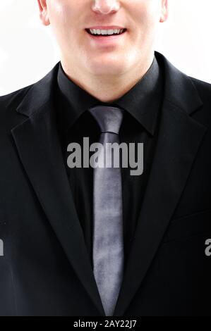 Closeup image of a smiling guy in black suit Stock Photo