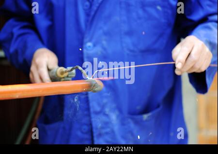 Worker in blue suit welding metal Stock Photo