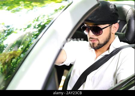 Young man driving a car with Stock Photo