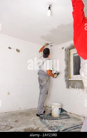 Construction workers painting walls Stock Photo