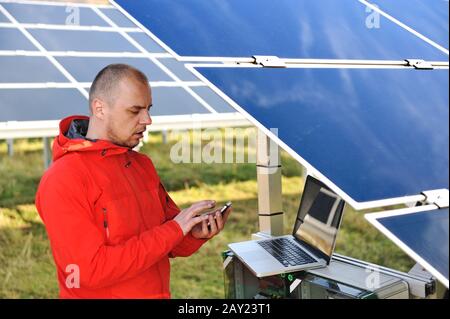 Engineer working with laptop by solar panels Stock Photo