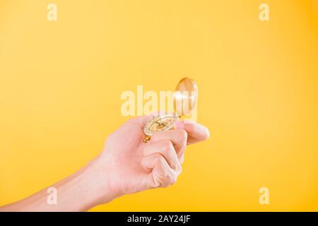 Hand holding antique brass compass isolated on yellow background with copy space for text Stock Photo