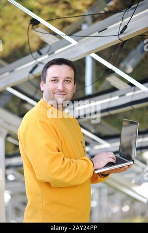 Engineer using laptop and connecting wires at work place Stock Photo