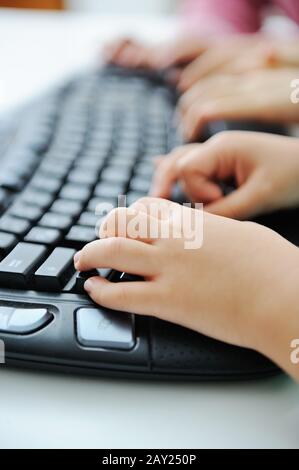 Child hands typing on keyboard Stock Photo
