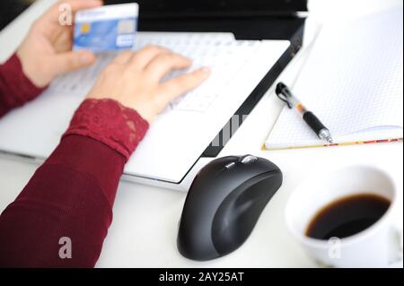 Close-up of female hand on mouse while working on laptop Stock Photo