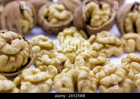 Peeled nuts. Walnuts, kernels and shells on a white background. Stock Photo