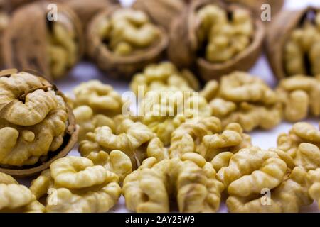 Walnut kernels with peeled nuts on a white background. Stock Photo