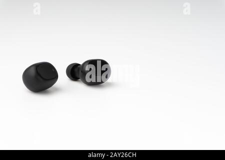 Wireless earbuds or earphones on white background. Copy space and technology concept Stock Photo