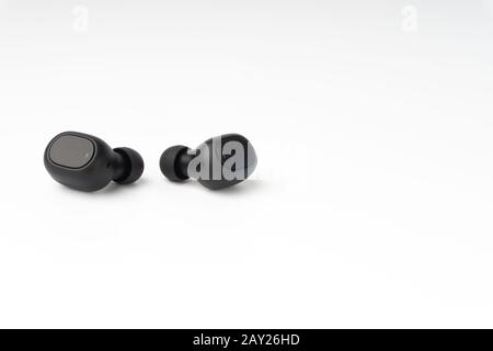 Wireless earbuds or earphones on white background. Copy space and technology concept Stock Photo