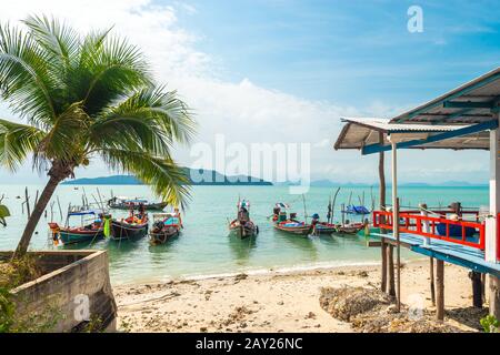 Koh Samui, Thailand - January 2, 2020: Authentic Thai fishing boats docked at Thong Krut beach in Taling Ngam on a day