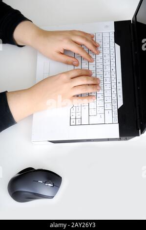 Close-up of female hand on mouse while working on laptop Stock Photo