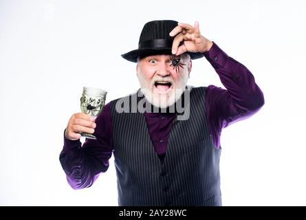 Halloween is not just for candy anymore. evil wizard cooking magic potion with spider. man magician in witch hat. barman make cocktail for halloween party. halloween holiday costume. happy halloween. Stock Photo