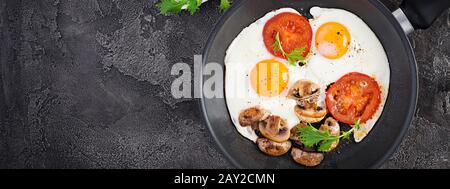 Ketogenic food. Fried egg, mushrooms and sliced tomatoes. Keto, paleo breakfast. Top view, banner Stock Photo