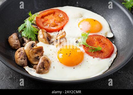 Ketogenic food. Fried egg, mushrooms and sliced tomatoes. Keto, paleo breakfast. Stock Photo