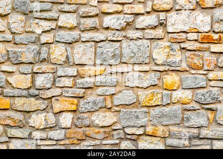 Stone wall. Wall of stones as a texture. Wall of stones. wall of a medieval fortress with mainly white or light colored stones of varying sizes and shapes, usable as background pattern or for designs Stock Photo