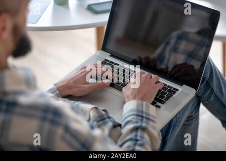 Man working on a netbook typing text. Stock Photo