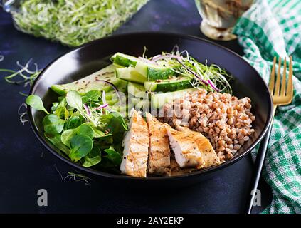 Lunch salad. Buddha bowl with buckwheat porridge, grilled chicken fillet, corn salad, microgreens and daikon. Healthy food. Stock Photo