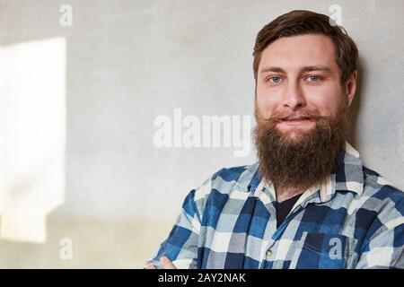 Smiling young hipster man with full beard as a worker or handyman Stock Photo
