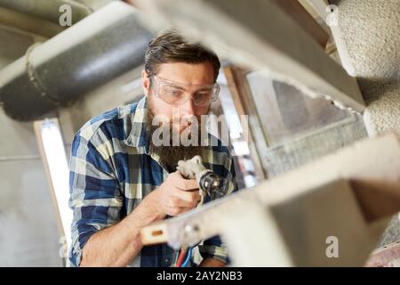 Varnishers when painting wood with the spray gun or paint gun Stock Photo