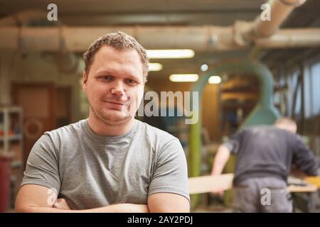 Young man as a craftsman apprentice in a carpentry or carpentry workshop Stock Photo