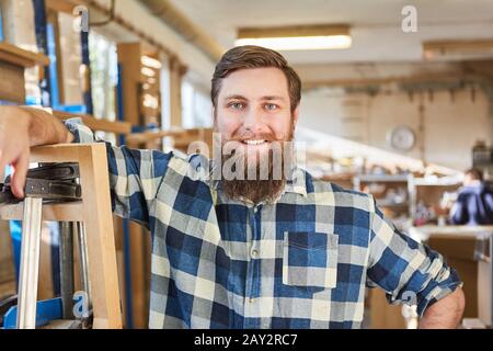 Young hipster man with a beard as a happy craftsman or founder Stock Photo