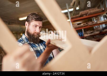 Hipster carpenter in training with lumber in carpentry or joinery Stock Photo