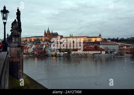 Prague, Czech Republic - December 2nd 2015: View from Charles bridge over river Moldau to illuminated castle and St. Vitus cathedral on evening Stock Photo