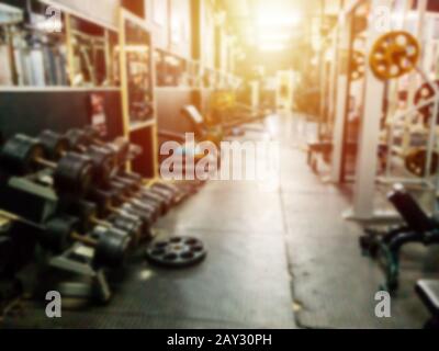 abstract blur dumbbell and weight lifting equipment in fitness gym background. exercise and workout for healthy life concept Stock Photo