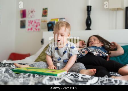 Brother and sister on bed Stock Photo