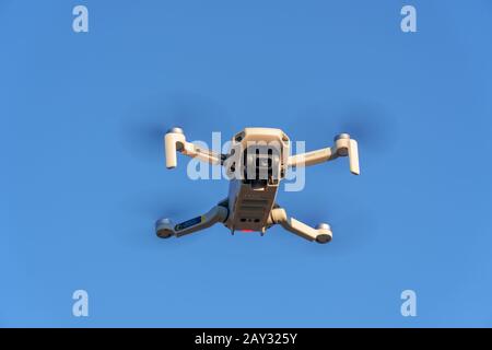 Zurich, Switzerland - December 01, 2019: DJI Mavic Mini drone in the air against the blue sky Stock Photo