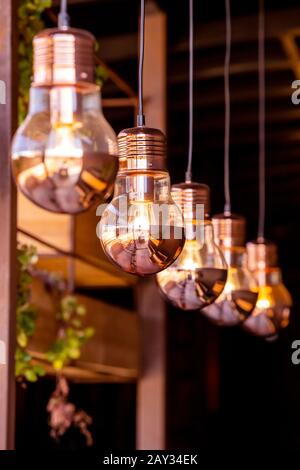Copper lightbulbs hanging from the ceiling in modern interior Stock Photo