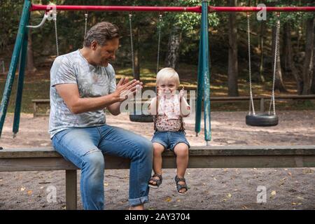 Father playing with son on playground Stock Photo