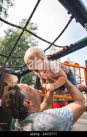 Father playing with son on playground Stock Photo