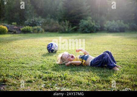 Happy boy lying on lawn Stock Photo