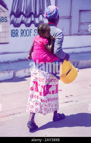 Johannesburg, South Africa , 4 October - 2019: Women carrying her child on her back using a cloth. Stock Photo