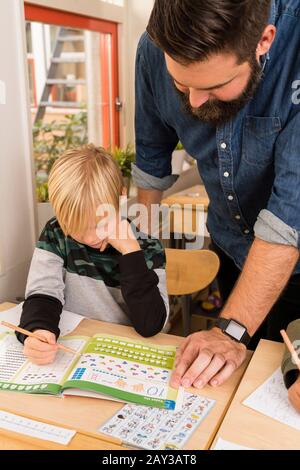 Teacher with boy in classroom Stock Photo