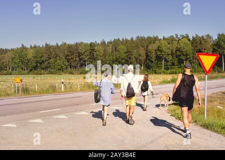 People walking along country road Stock Photo
