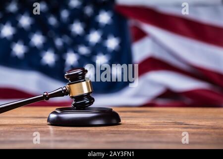 Wooden Gavel On Table In Front Of US Flag Stock Photo