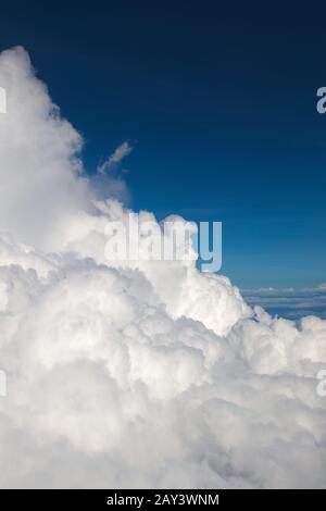 Fluffy clouds (Cumulonimbus) at high altitude over deep blue sky. Heaven, freedom, purity concept. Stock Photo
