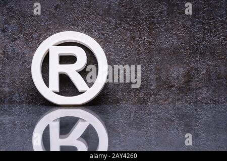 White Registered Trademark Sign Leaning On Wall Stock Photo