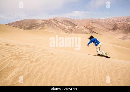 Sandboarding on Atacama Desert. Iquique, Tarapaca Region, Chile. Stock Photo