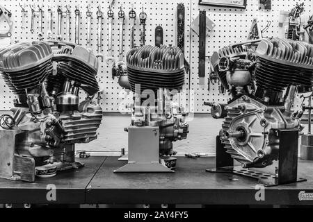 three old harley davidson motors on display in a motorcycle garage. Stock Photo