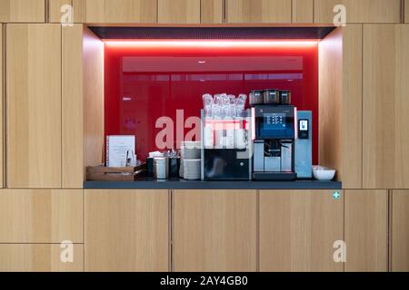10 February 2020, Brandenburg, Potsdam: A WMF brand coffee machine with coffee beans as well as stacked clean dishes such as glasses, saucers and cups are placed in the recess of a wall cupboard. Photo: Soeren Stache/dpa-Zentralbild/ZB Stock Photo