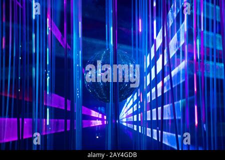 Dance floor disco night with a mirror ball symbol of fun and party in a nightclub or dance club with glowing stage lights and reflections, blue Stock Photo