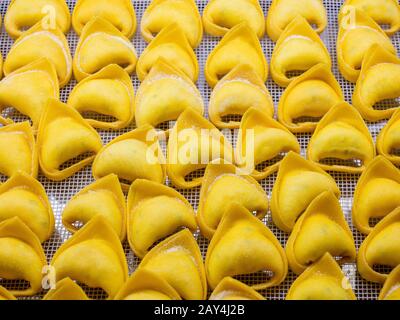 Tortellini pasta, freshly made raw pasta. Cooking healthy Italian home cooking. Background Stock Photo