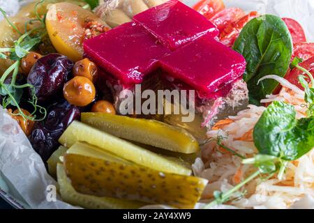 Celery and potato puree with pieces of red fish, garnished with herbs and fresh cucumbers. On a white plate with lemon slices. On a wooden table. Copy Stock Photo
