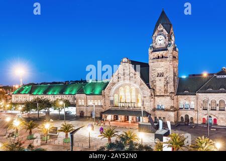 Night view of the illuminated old railway station building with clock tower in Metz city Stock Photo