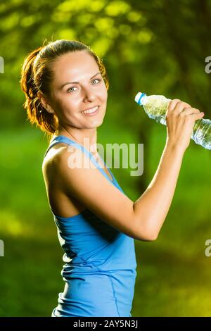 Young woman drinking water after fitness exercise Stock Photo