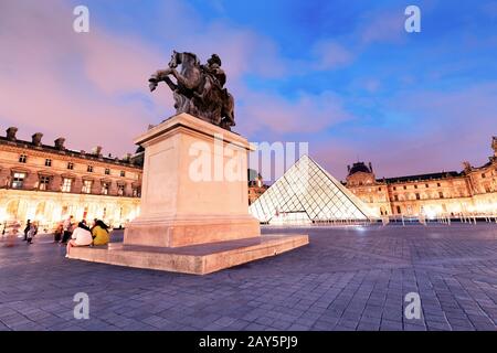 26 July 2019, Paris, France: Equestrian statue of king Louis XIV in the courtyard of the Louvre museum at evening time Stock Photo